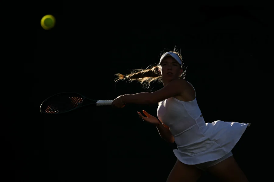 Tennis player in light and shadow on grass, Wimbledon 2024