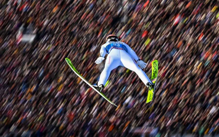 Ski jumper in flight above the crowd at the New Year's ski jump in Garmisch-Partenkirchen