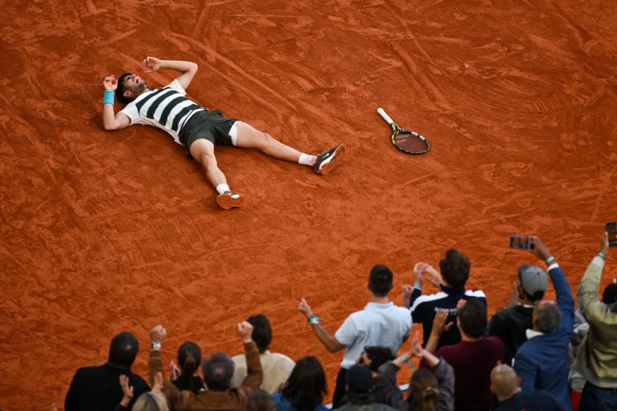 Carlos Alcaraz lying on the clay after winning the Roland Garros 2025 final