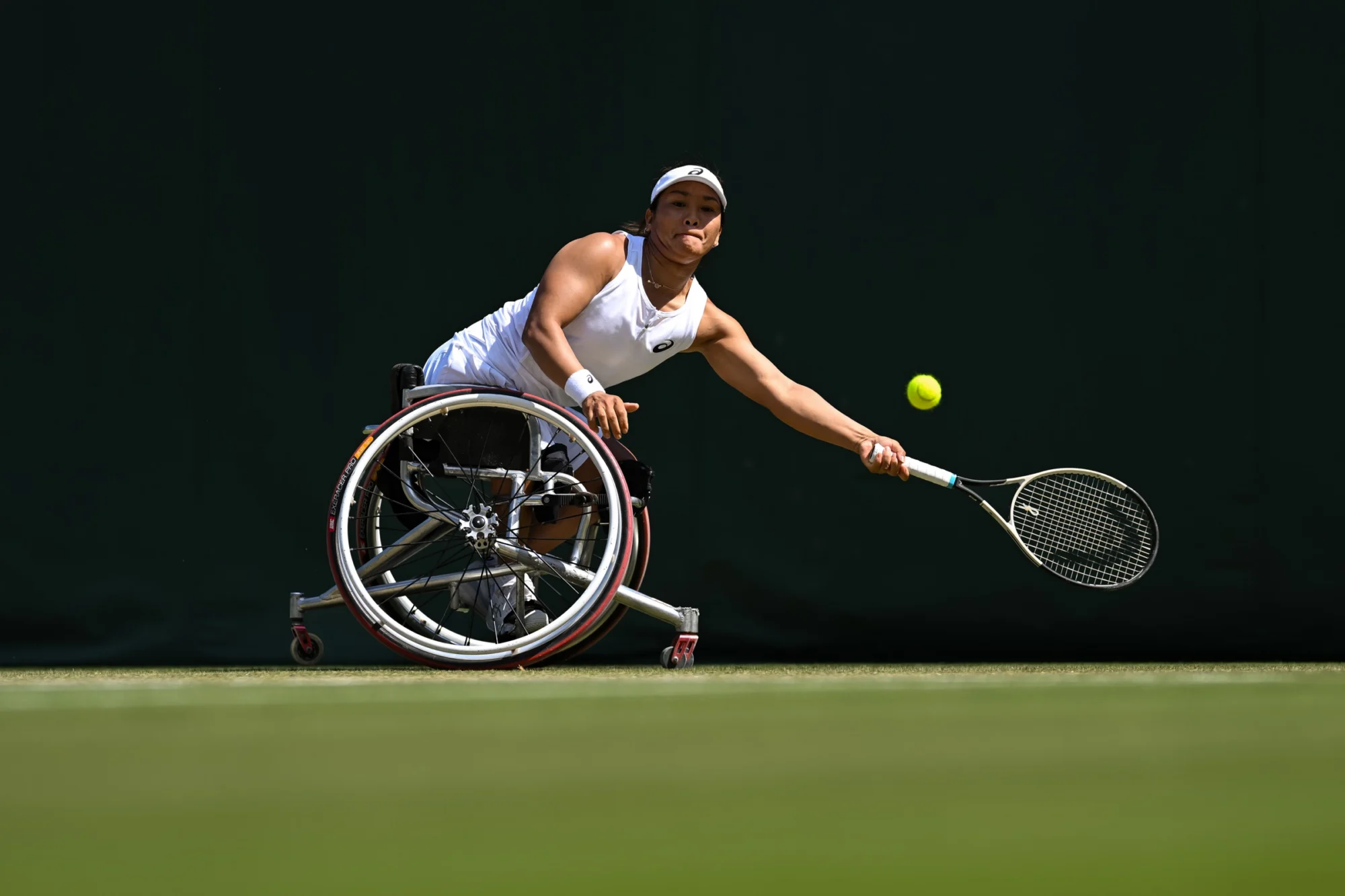 Wheelchair tennis player reaching for a forehand on grass, Wimbledon 2025